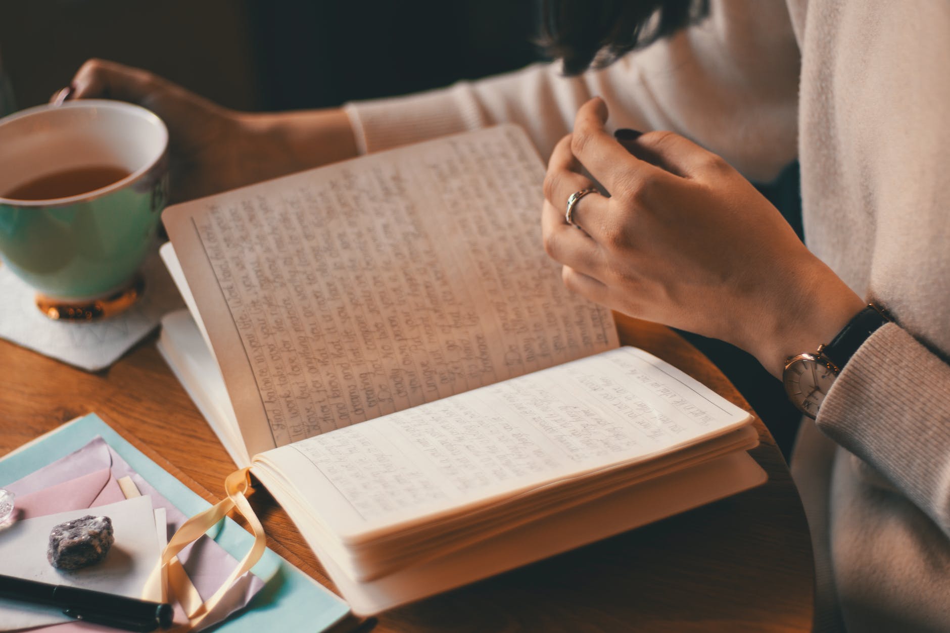 photo of person holding cup and reading a journal for gratitude practice. 