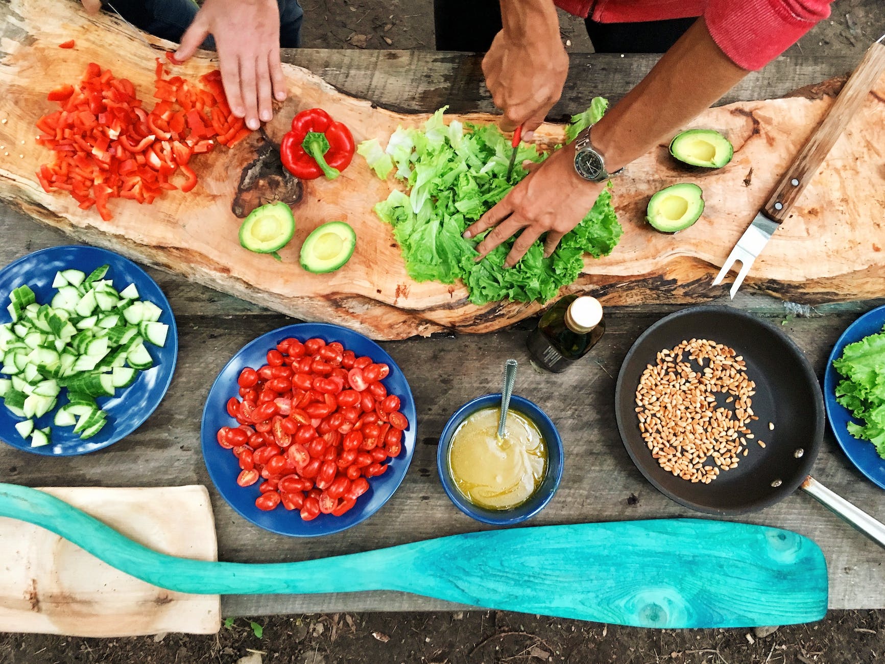 person slicing vegetables. A cooking class is something you can add to your life goals list. 