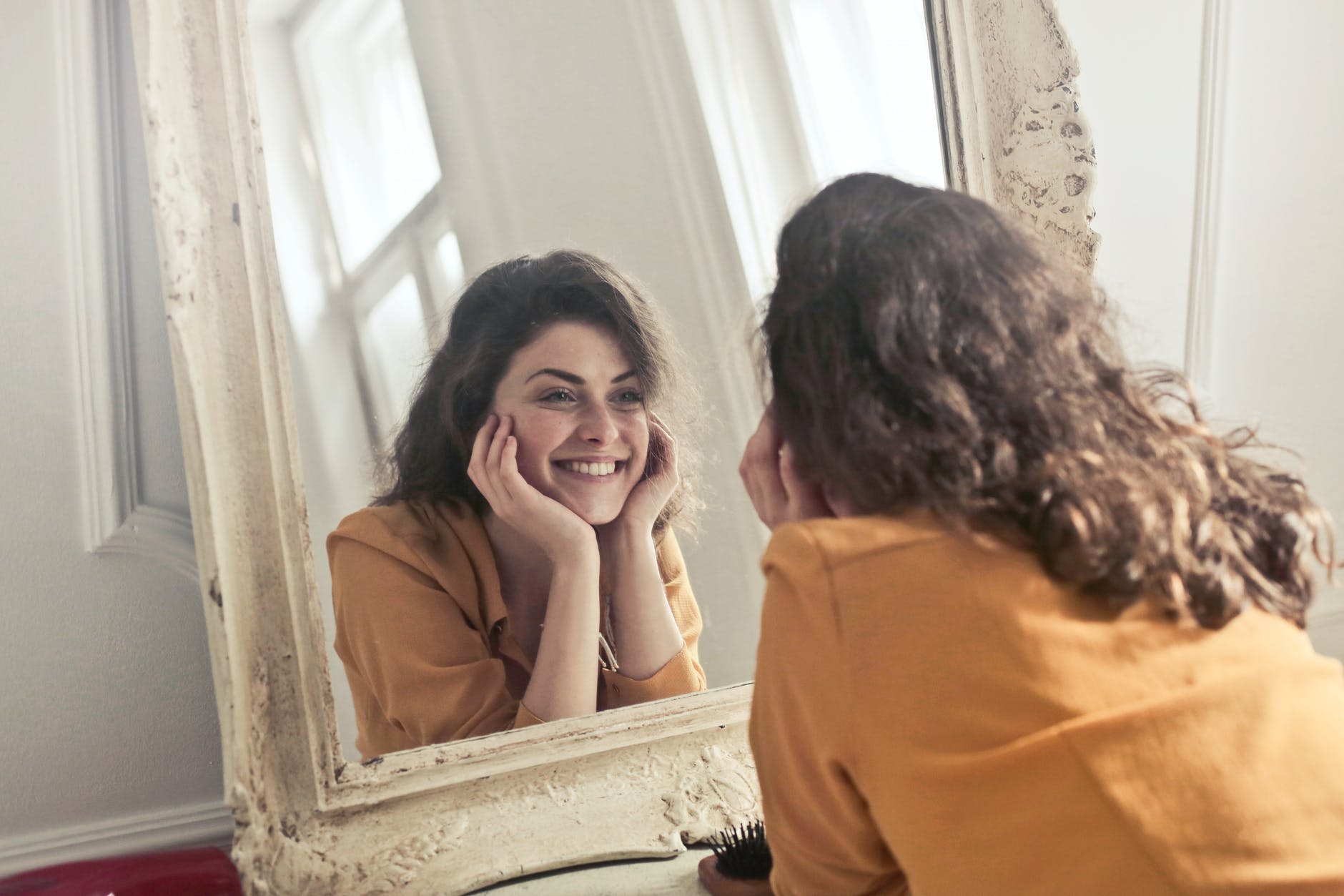 photo of woman looking at the mirror. daily confidence affirmations.