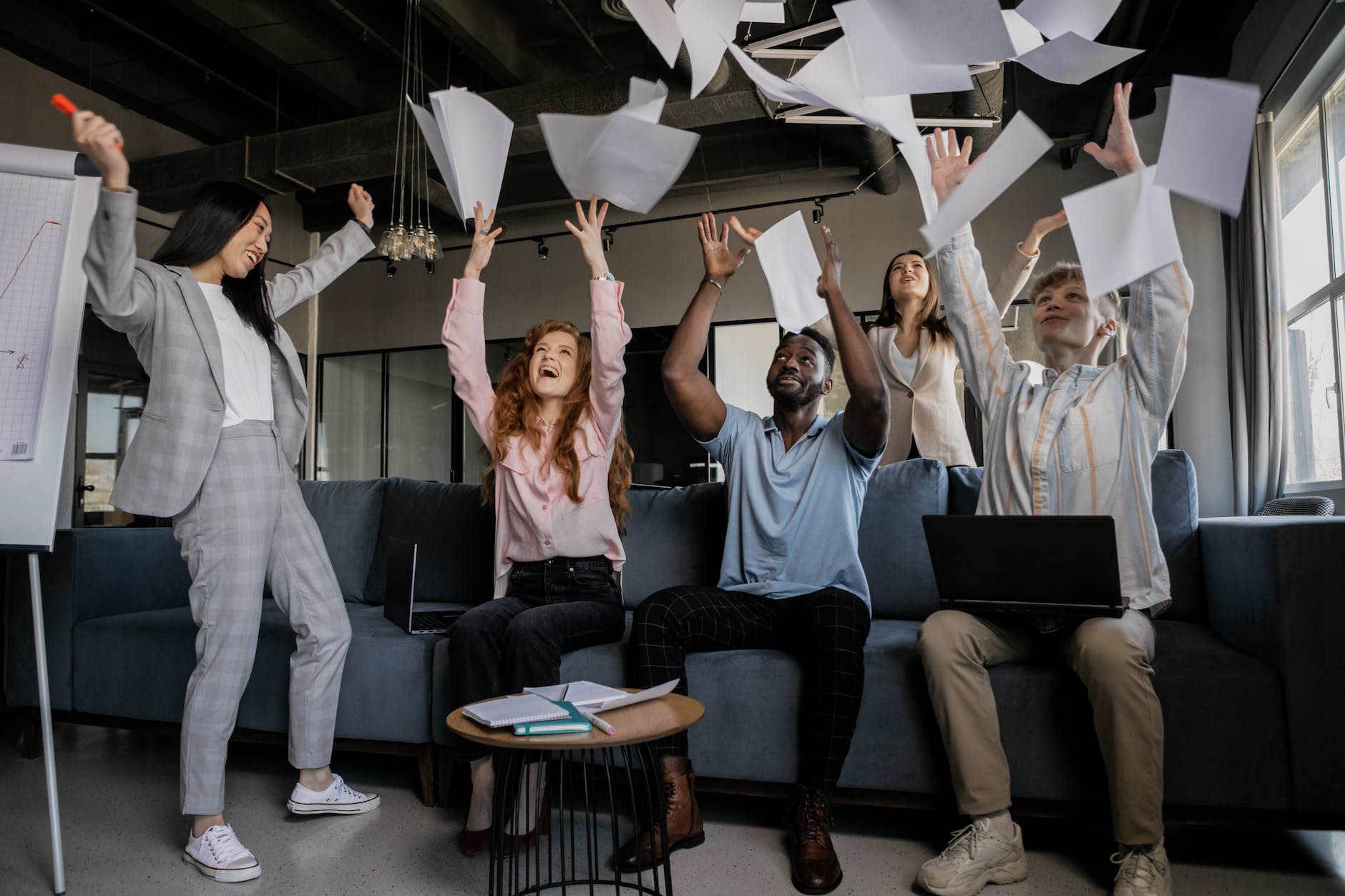 photo of coworkers throwing pieces of paper to show why failure is a necessary part of success