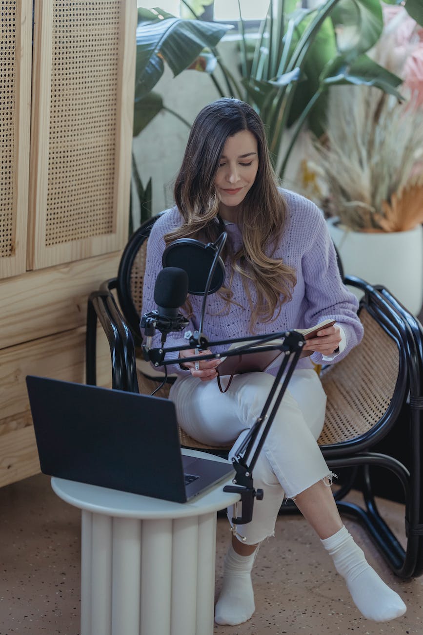 woman reading notes from notebook during radio broadcast. practice writing