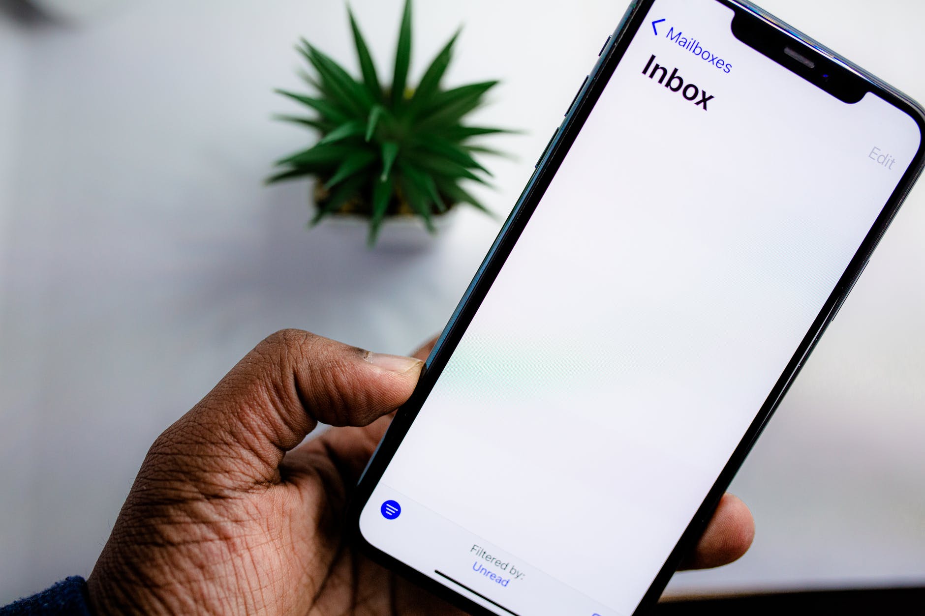 person holding a smartphone. How Many Emails Should I Have in my Inbox?